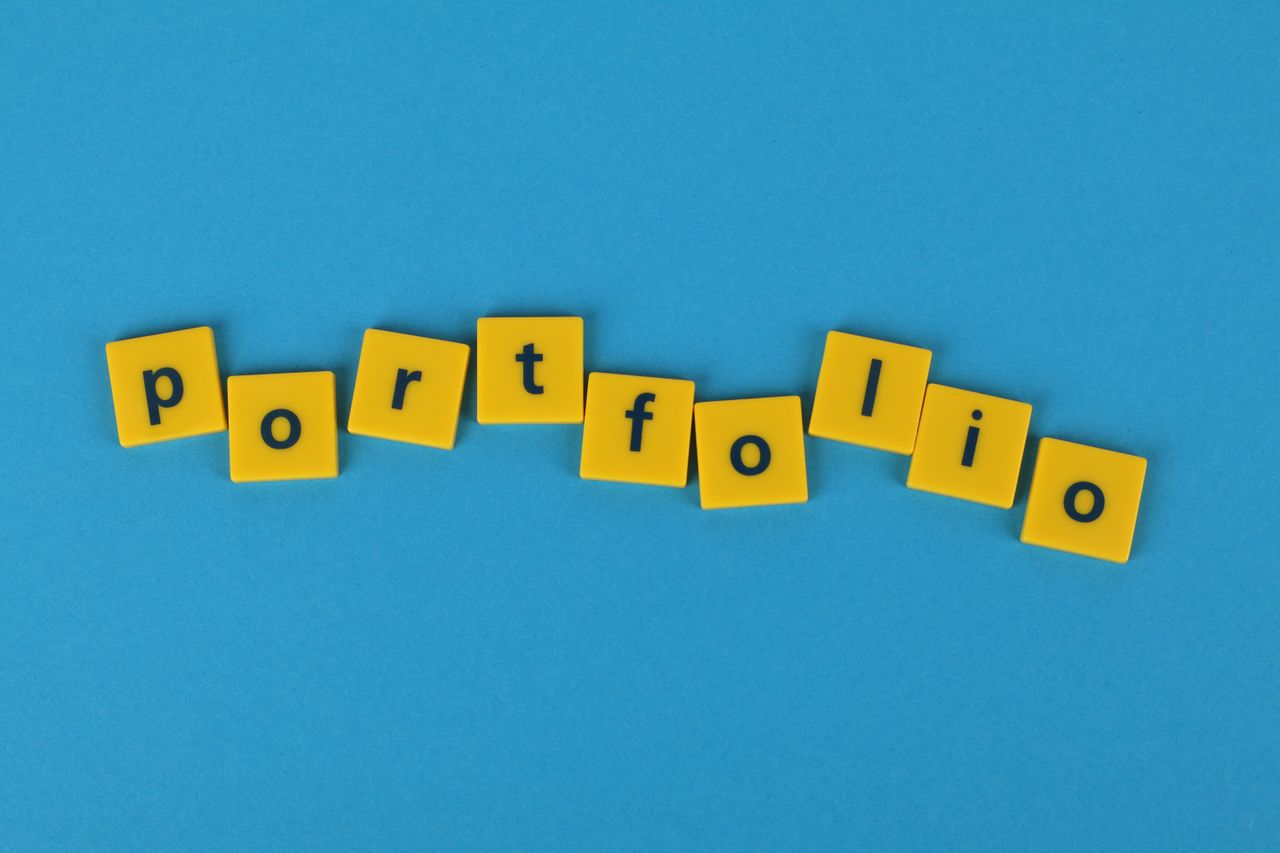 Yellow Scrabble tiles on a blue background spelling portfolio. Perfect for business themes.